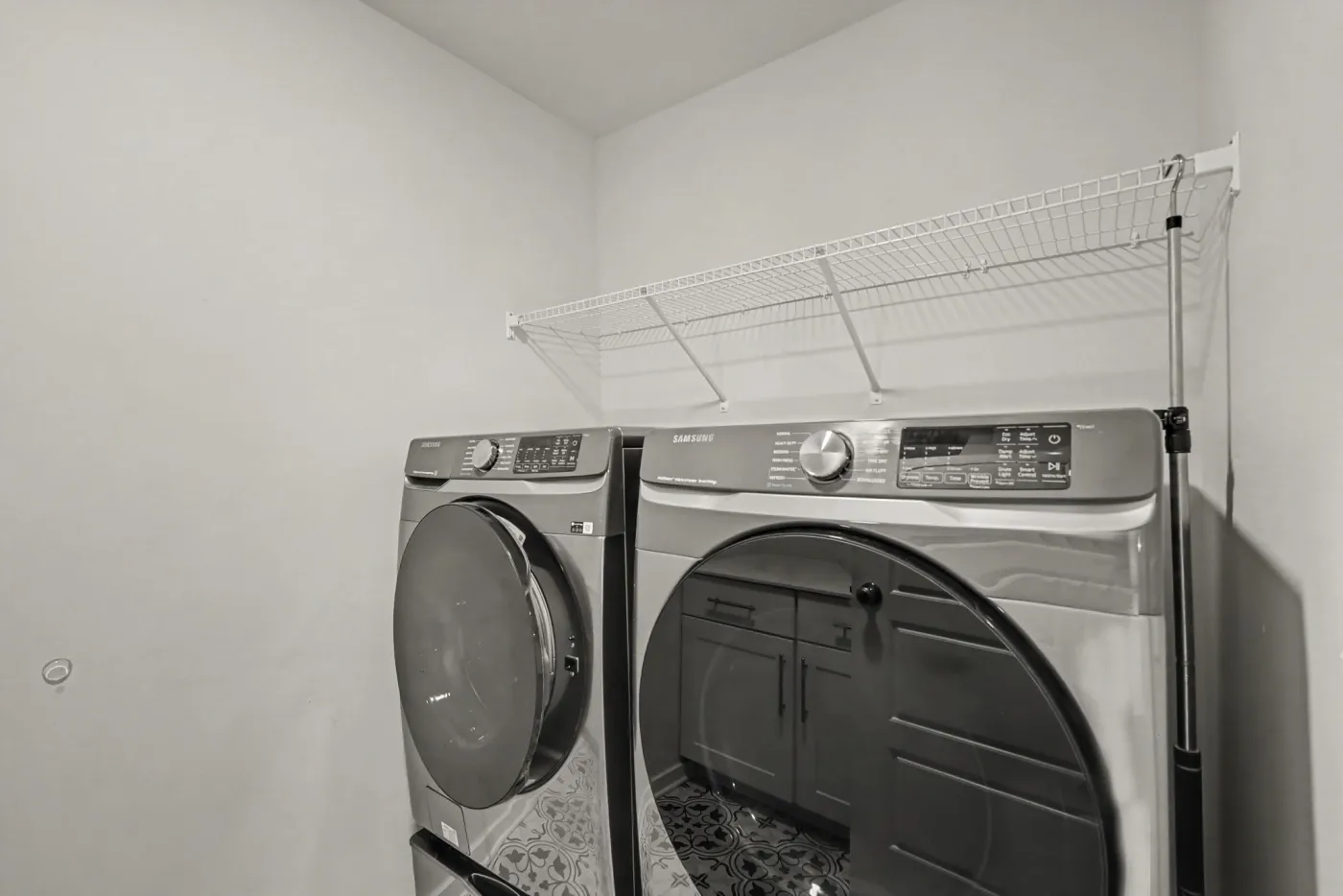 Upstairs laundry room with front-load washer and dryer and wire shelving
