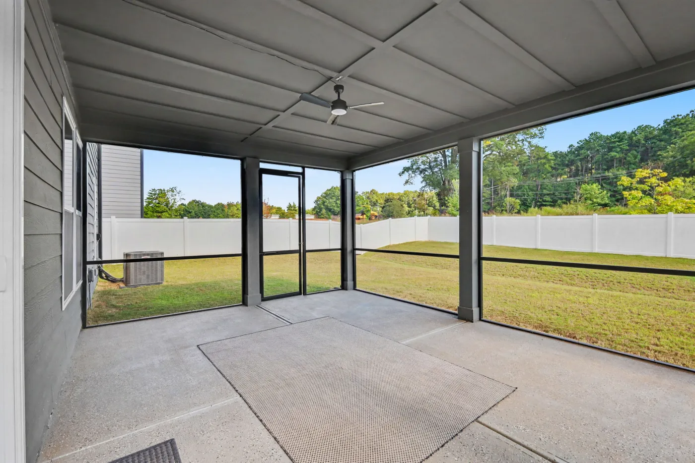 Screened porch with ceiling fan overlooking the fenced backyard